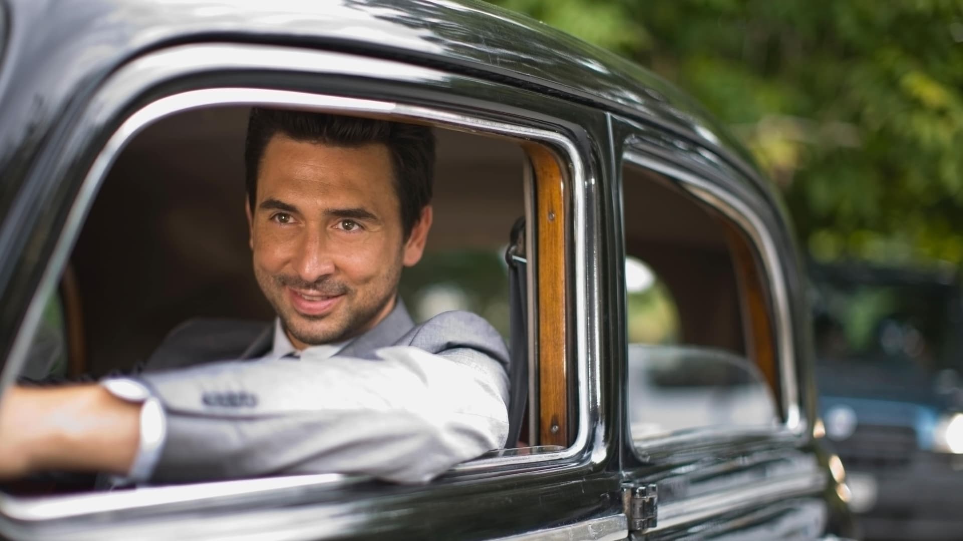 Ein Mann sitzt im Auto und blickt aus dem Fenster