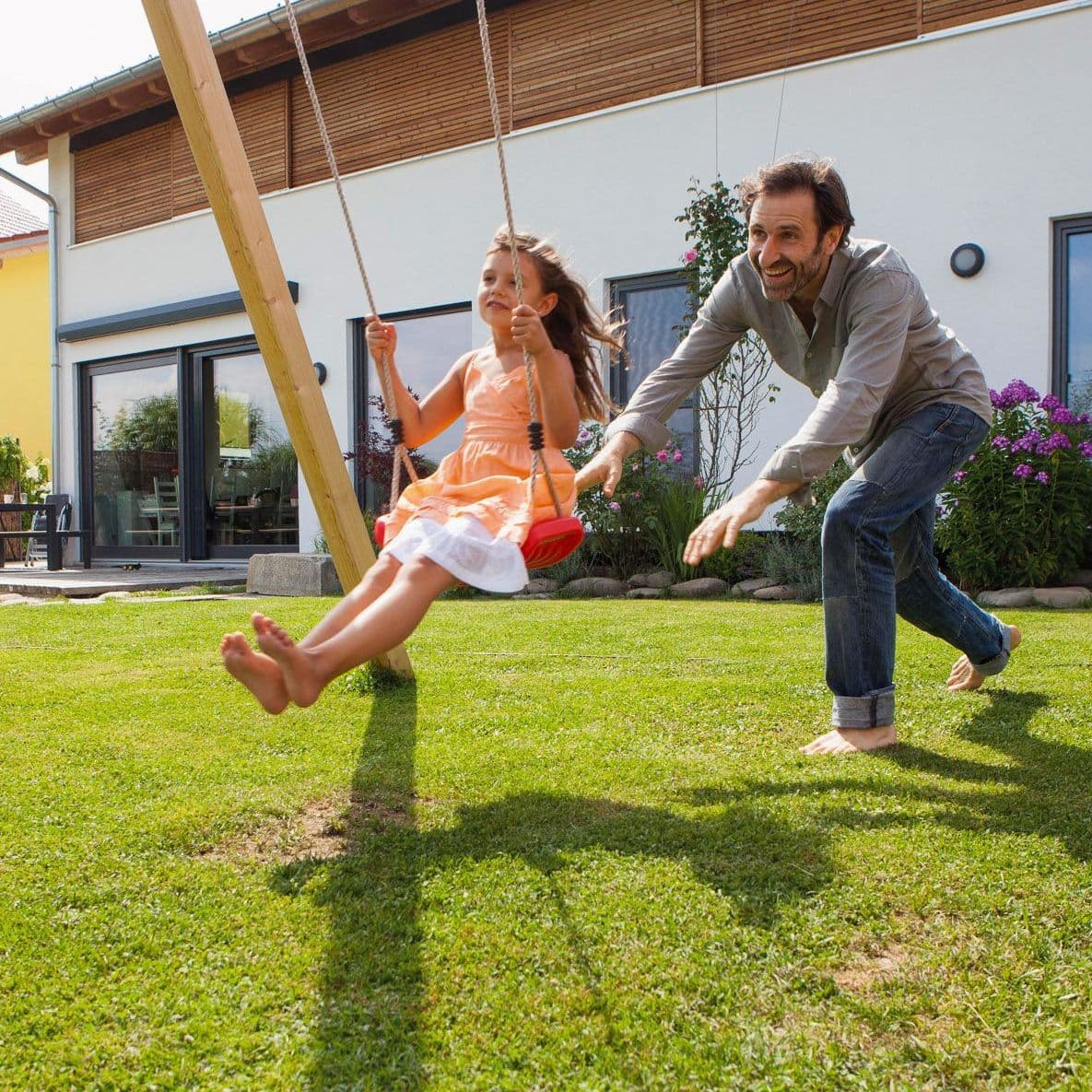 Vater und Kind an einer Schaukel.