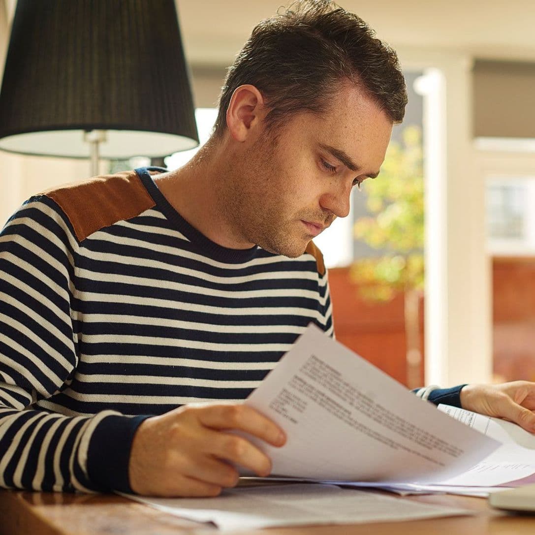 Mann blättert in Papier.