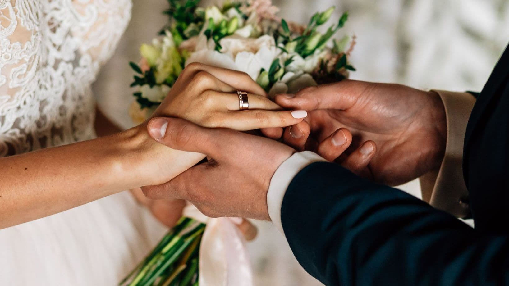 Brautpaar hält sich die Hände.