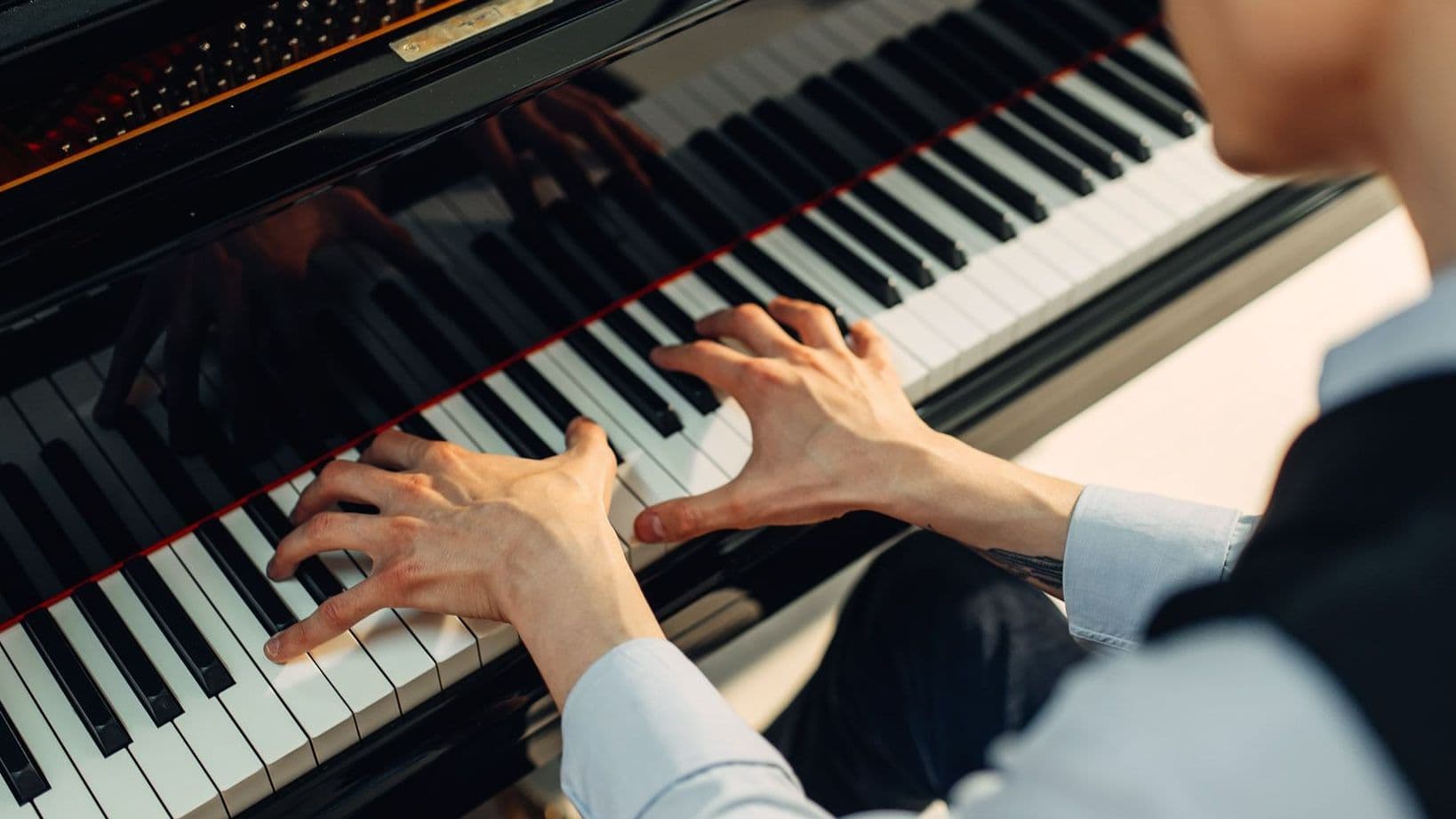 Mann spielt Klavier.