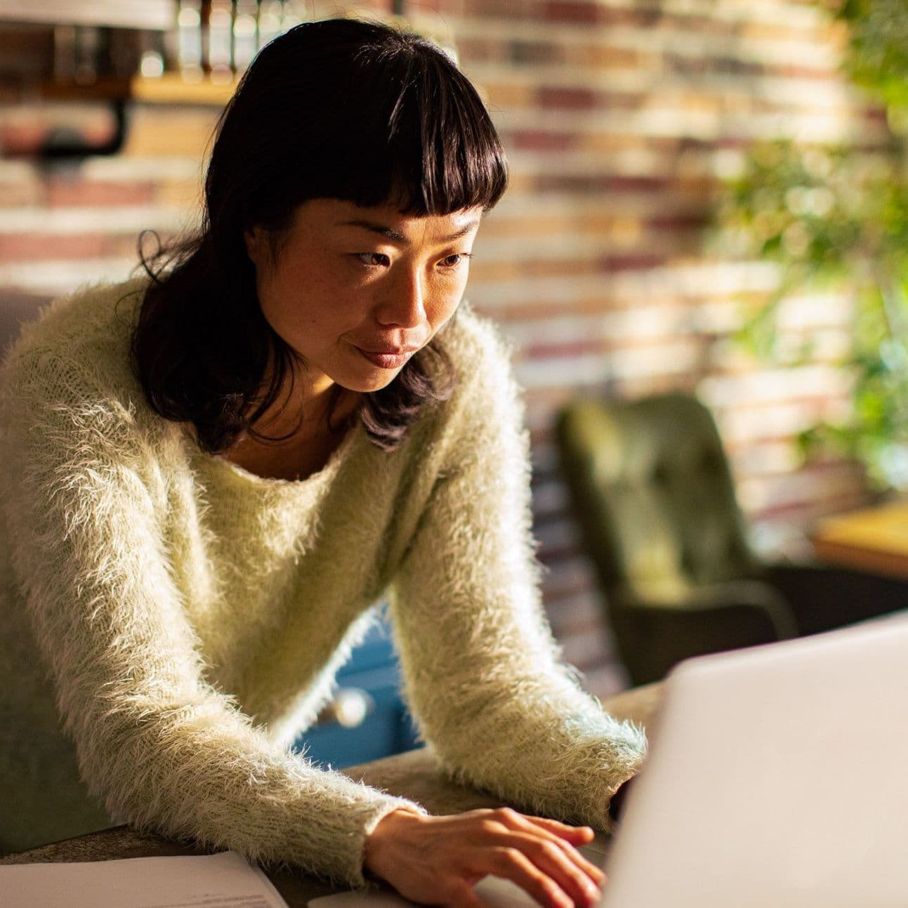 Frau tippt am Laptop.