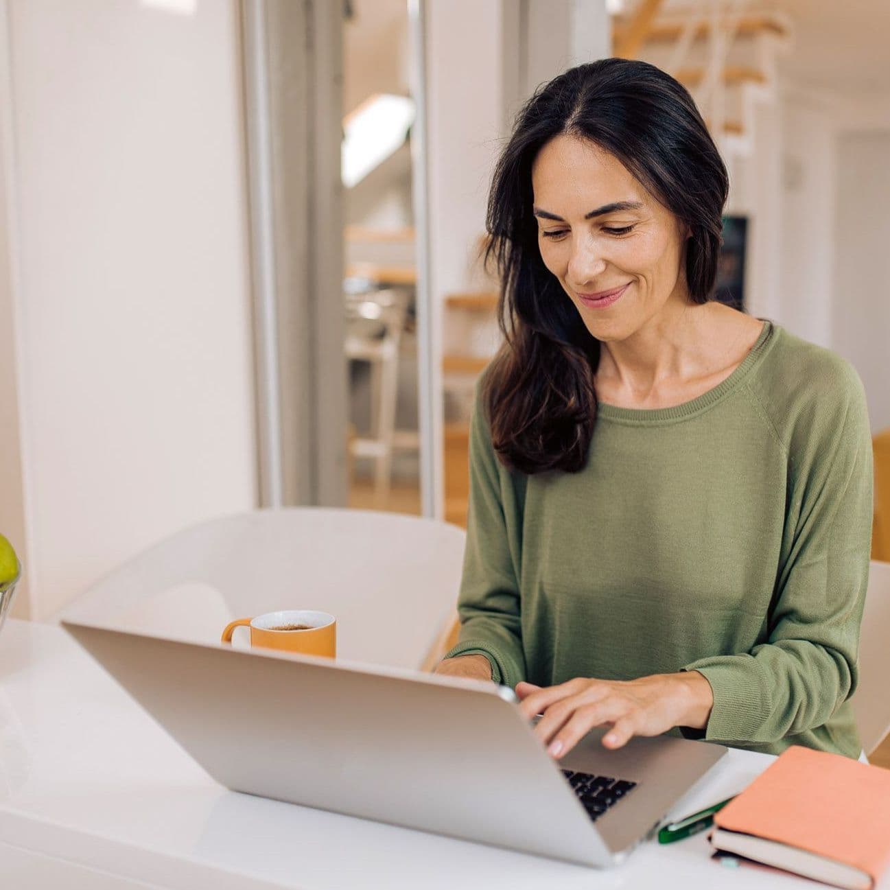 Frau sitzt am Laptop.