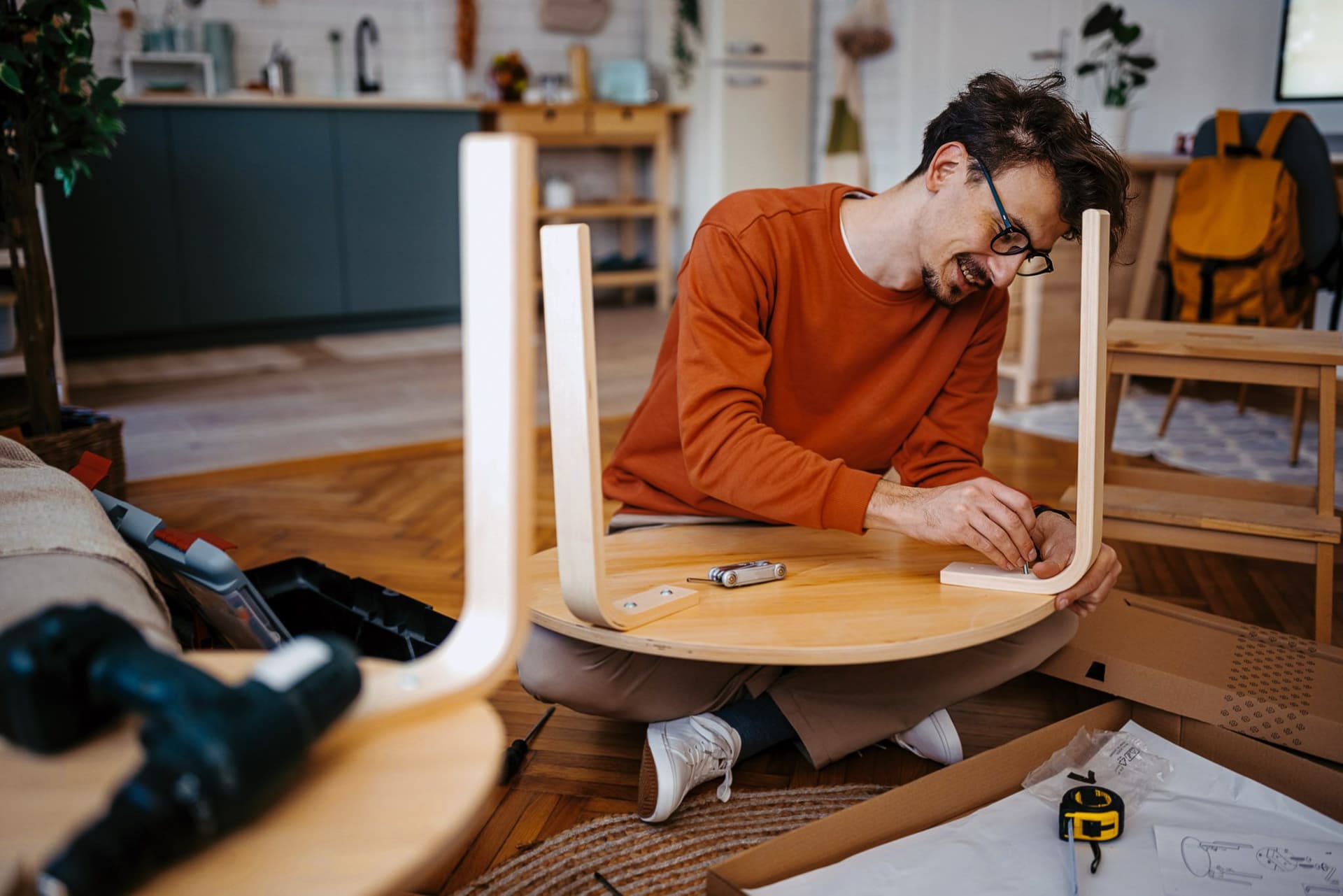 Mann baut Tisch zusammen.