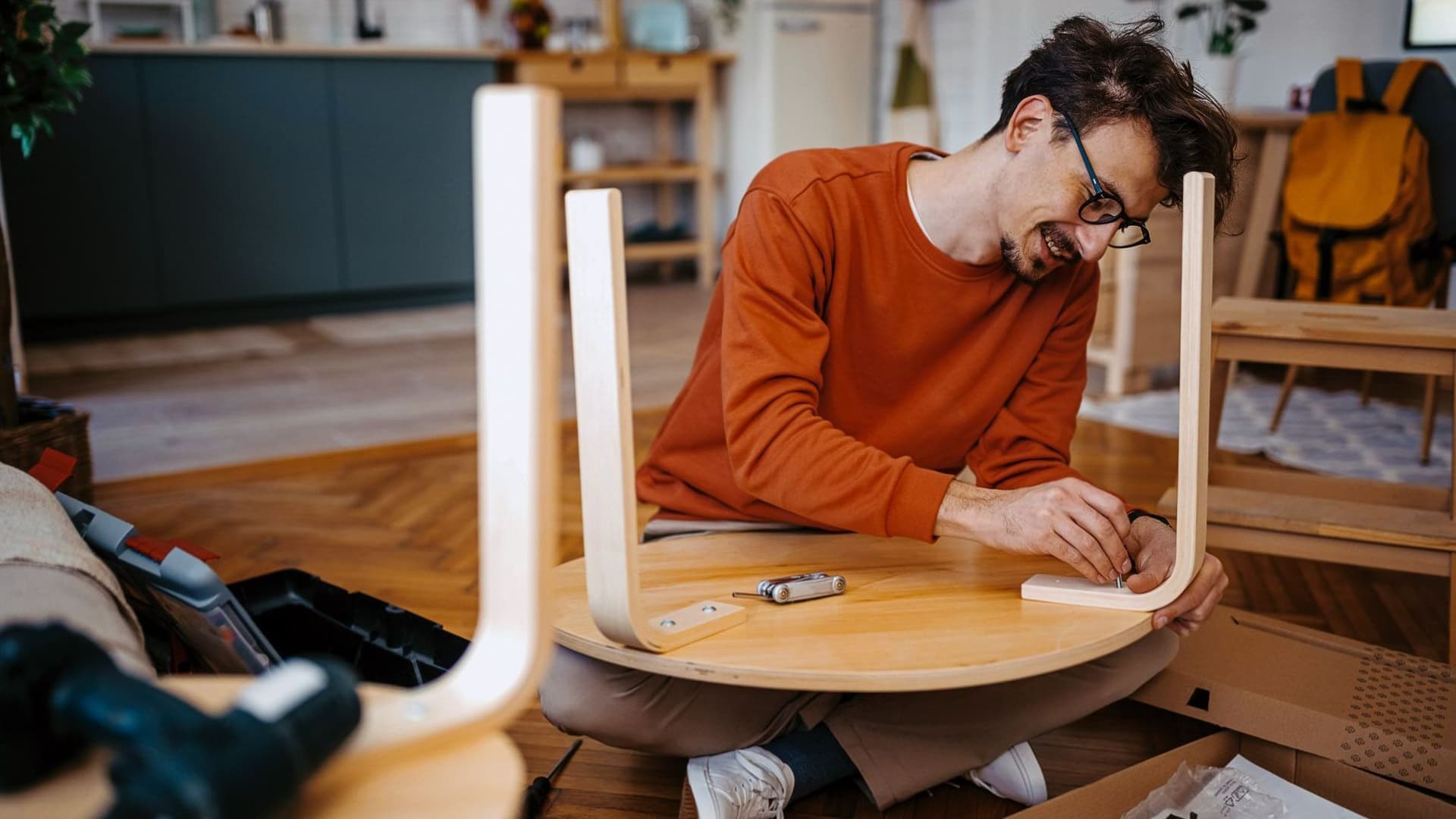 Mann baut Tisch zusammen.