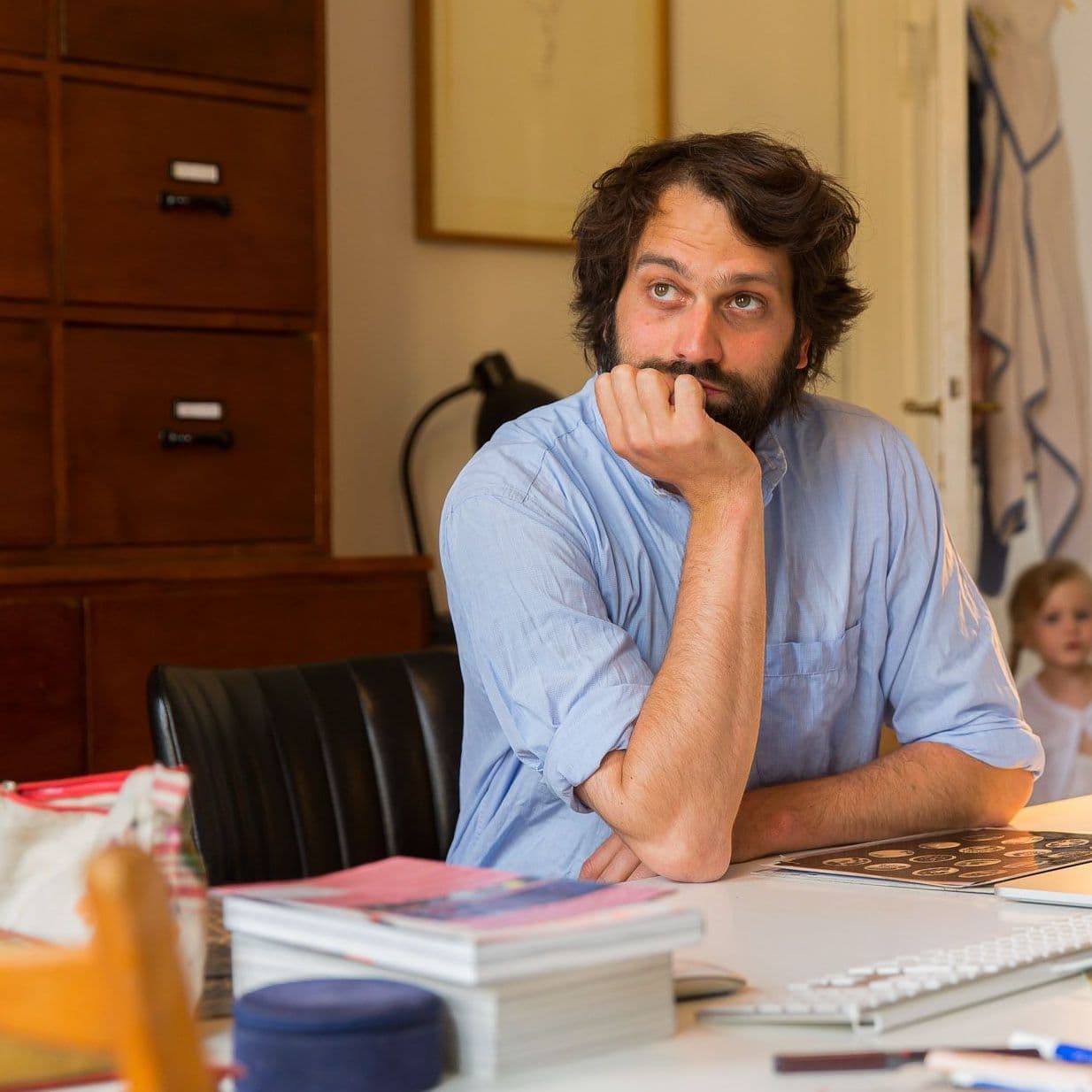 Mann sitzt am Schreibtisch und guckt nachdenklich.