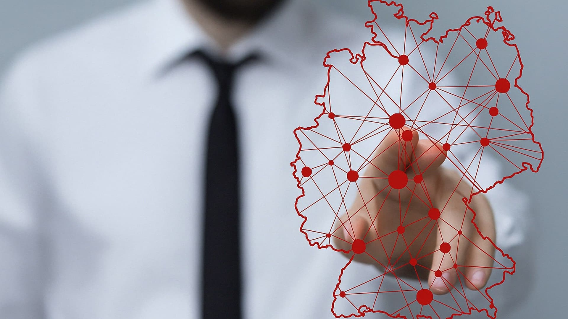 Ein Mann tippt auf eine stilisierte Deutschlandkarte.