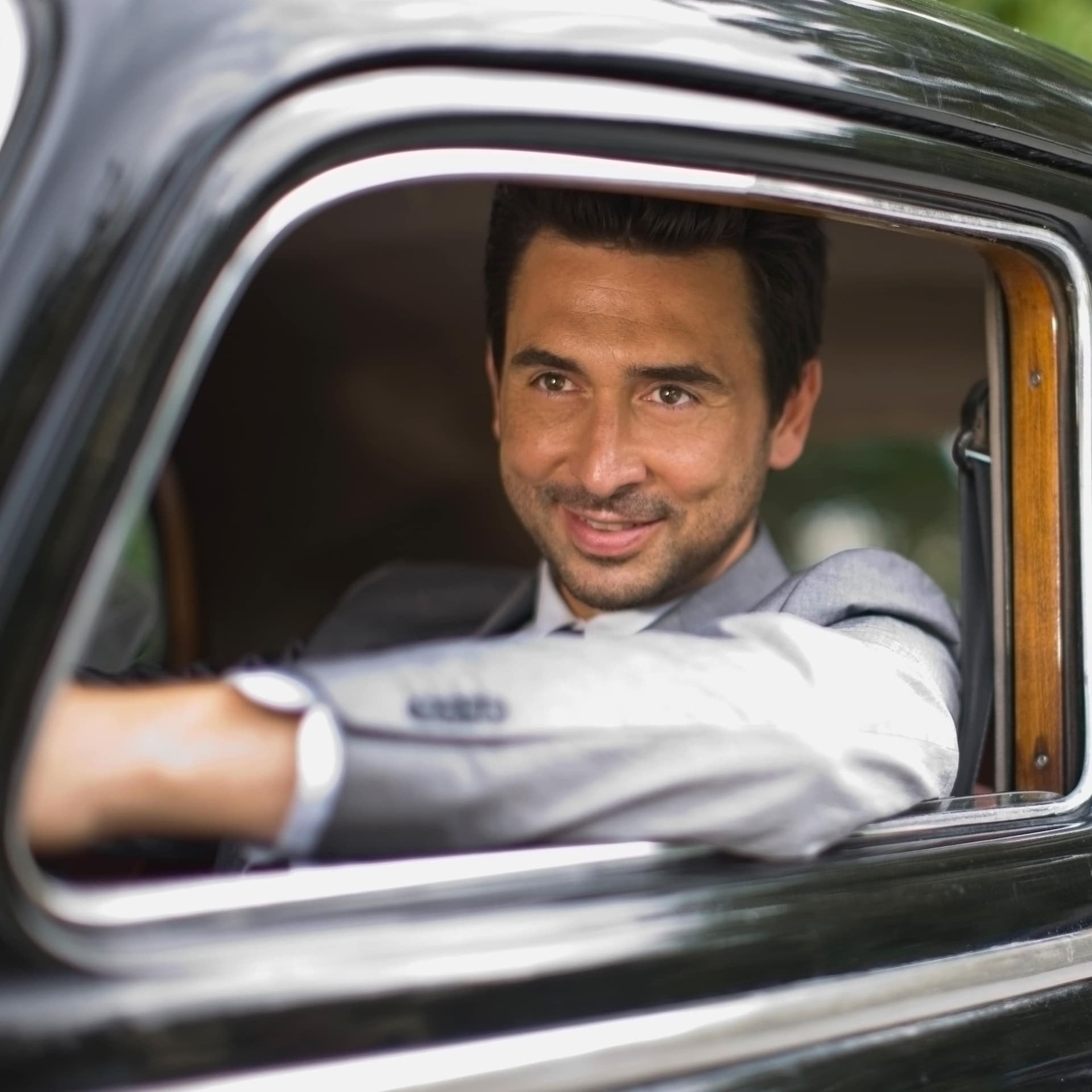 Ein Mann sitzt im Auto und blickt aus dem Fenster