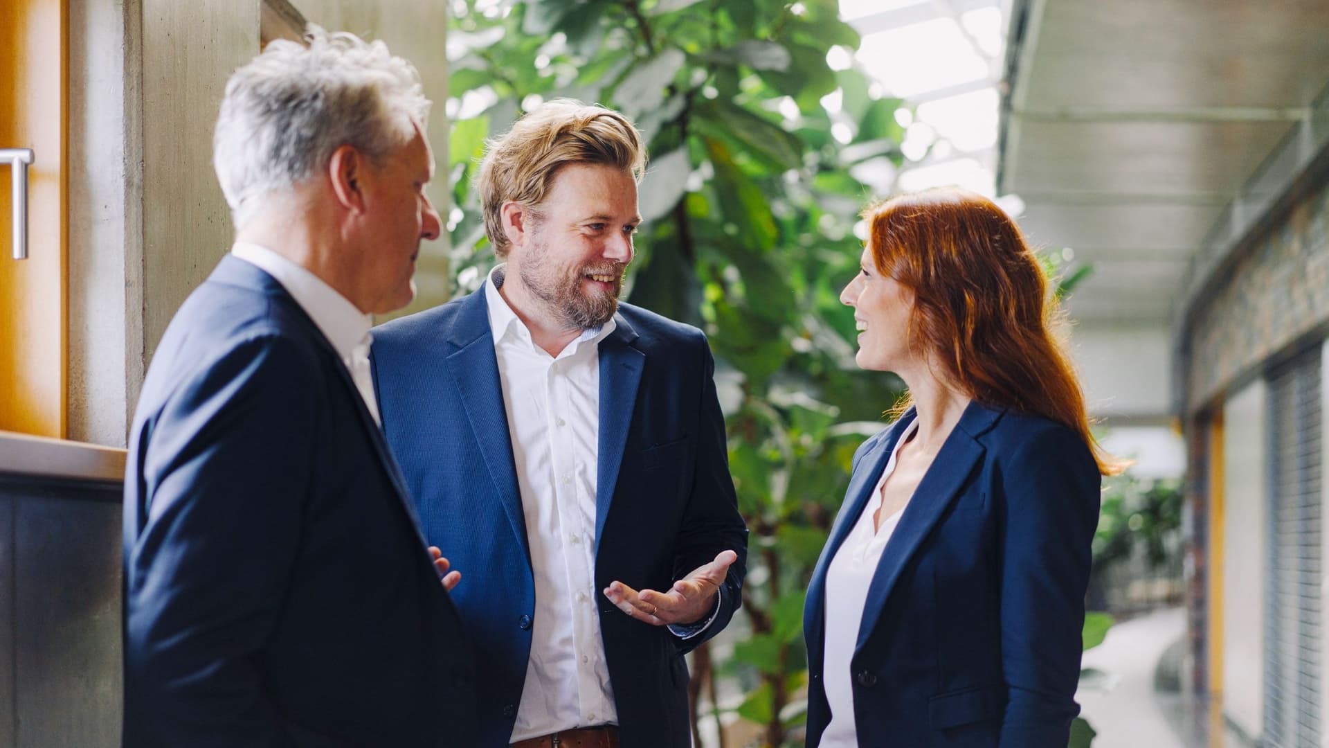 Drei Personen stehen zusammen und unterhalten sich.