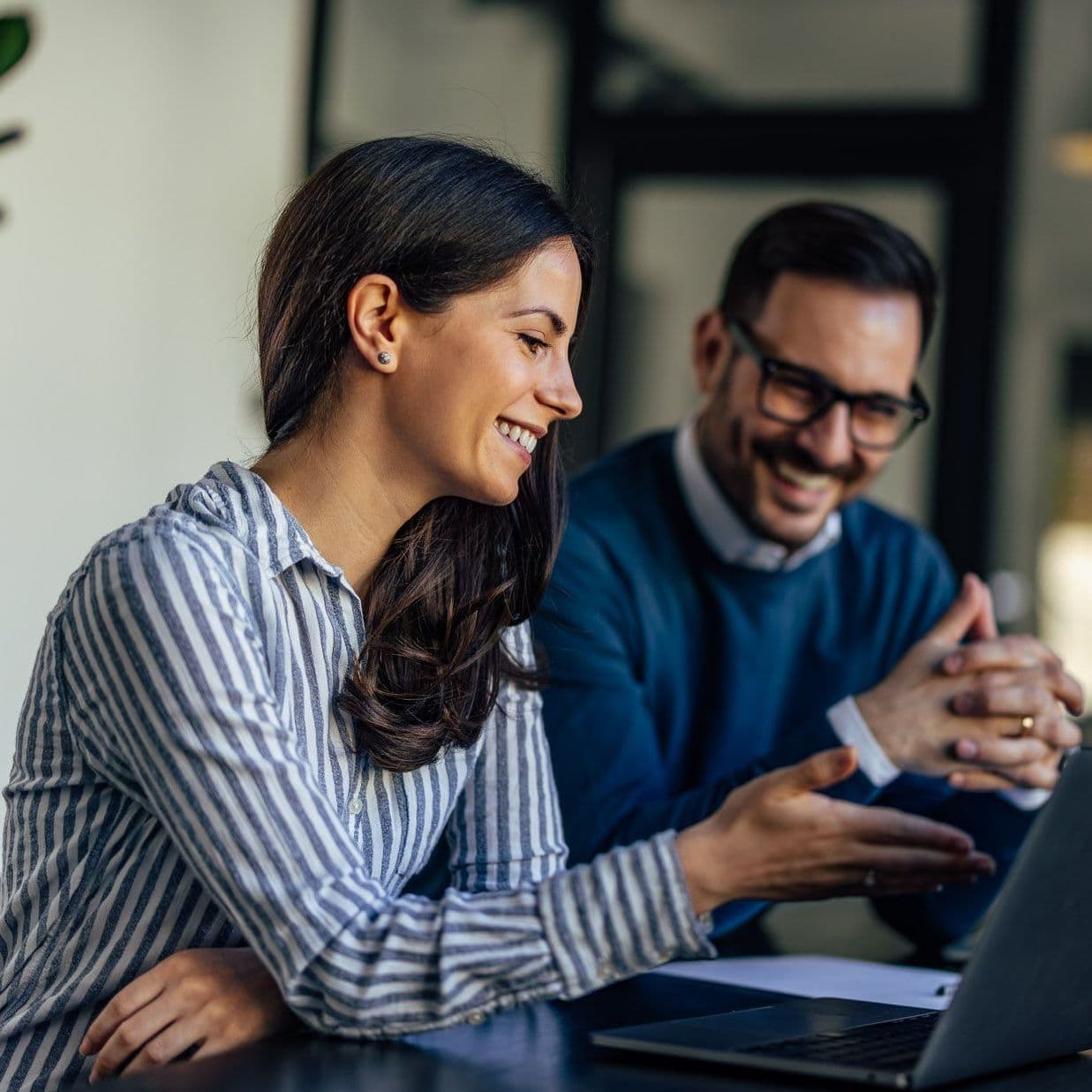 Mann und FRau sitzen vorm Laptop.